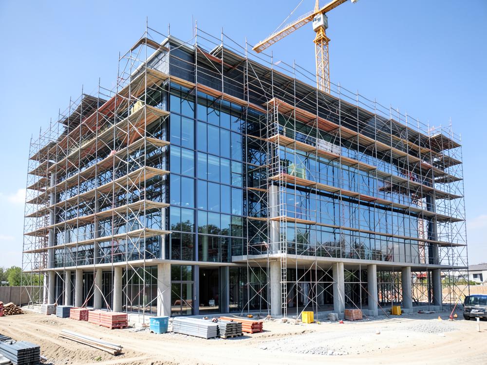Modern commercial building under construction with glass curtain wall installation